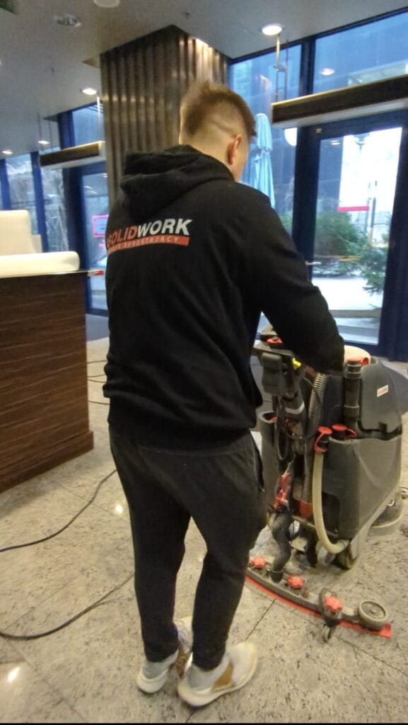 Pracownik Solid Work, myjący maszyną posadzkę w trakcie sprzątanie V Tower dla produkcji filmowej