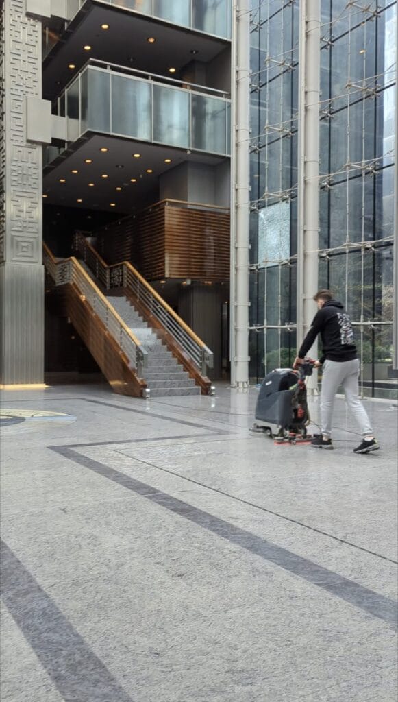 Pracownik Solid Work, myjący maszyną posadzkę w trakcie sprzątanie V Tower dla produkcji filmowej