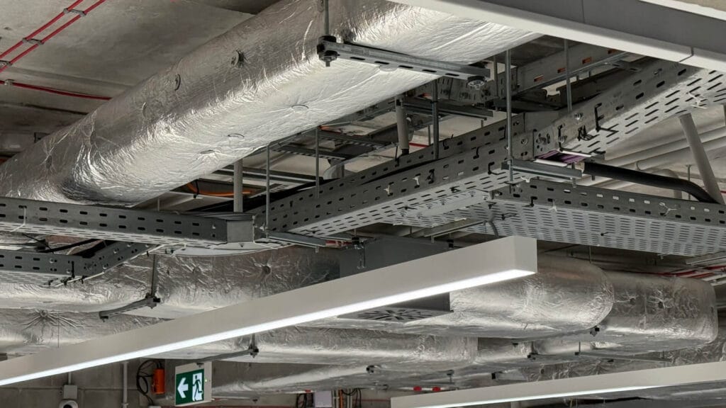 sprzątanie w muzeum sztuki nowoczesnej, widok na sufit z instalacją odpowietrzającą owiniętą srebrną izolacją