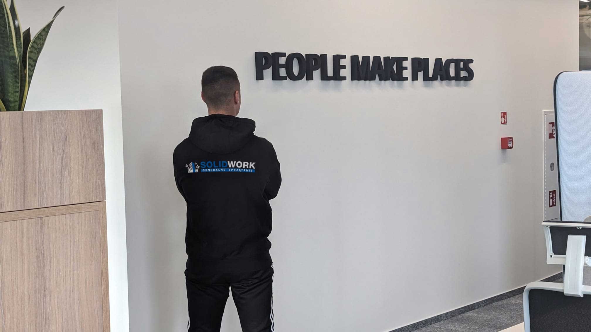 Pracownik Solid Work z logo na plecach swojej bluzy we wnętrzu firmy ISS