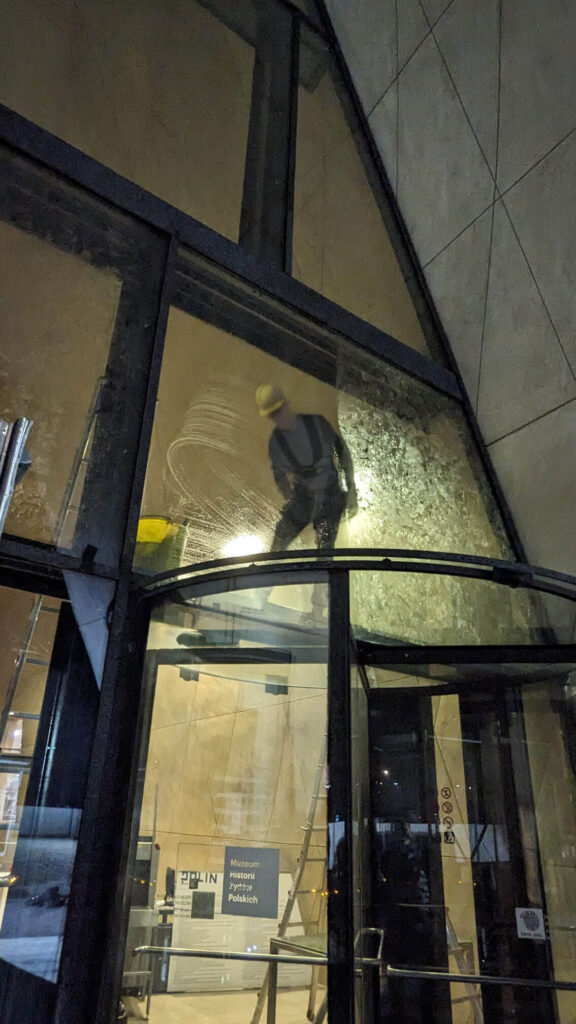 Mycie okien na wysokości w Muzeum POLIN. Widok z zewnątrz.