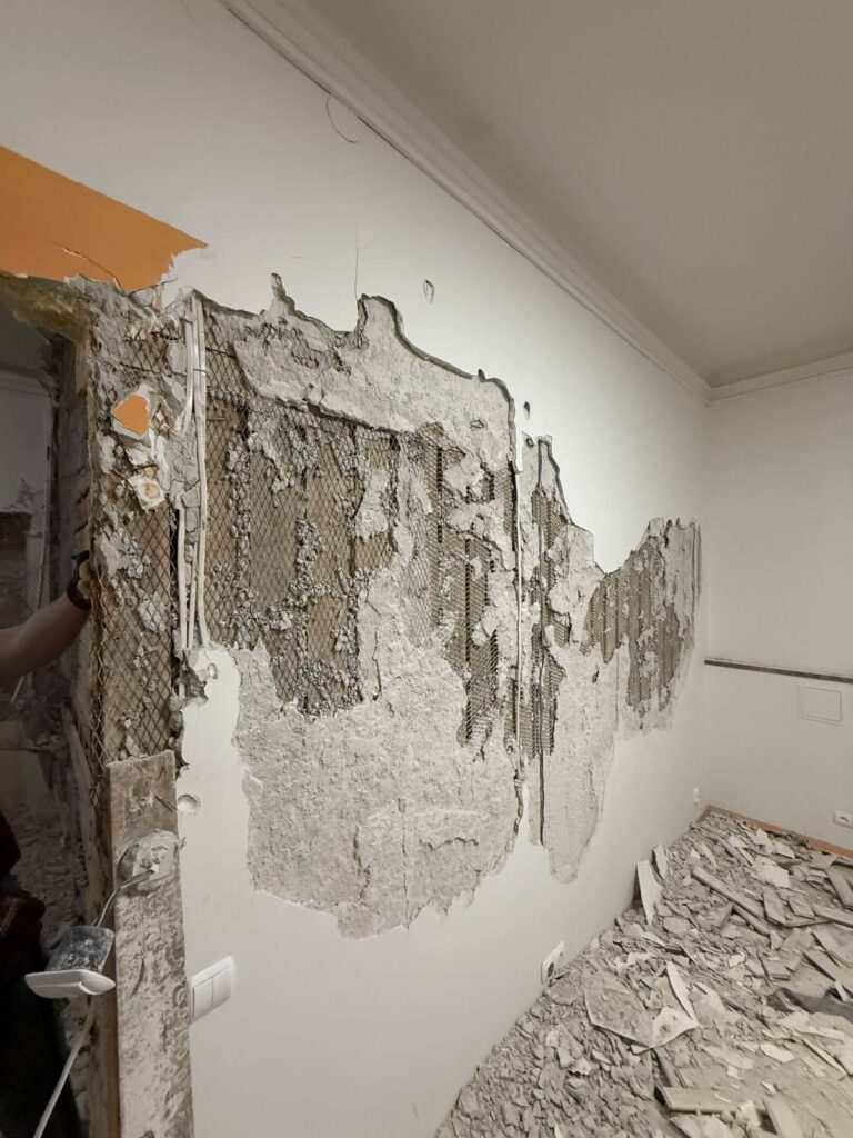 Kucie tynków i demontaż ściany podczas prac przygotowawczych do remontu w Warszawie przy ul. Nowy Świat